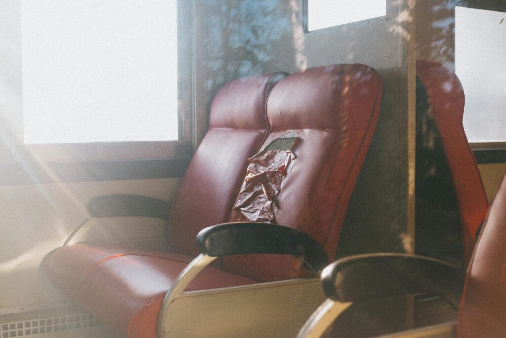 pexels-photo-9381641-9381641 Close-up of vintage red leather seats with sunlight highlighting wear and tear.